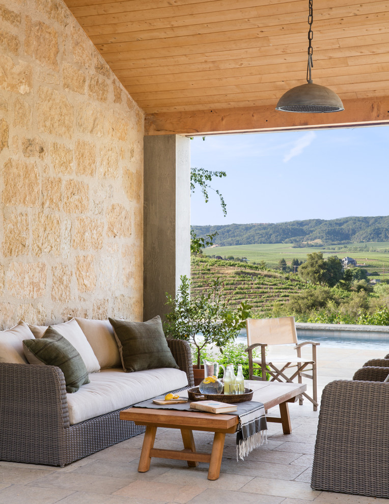 Patio - country backyard stone patio idea in San Francisco with a roof extension