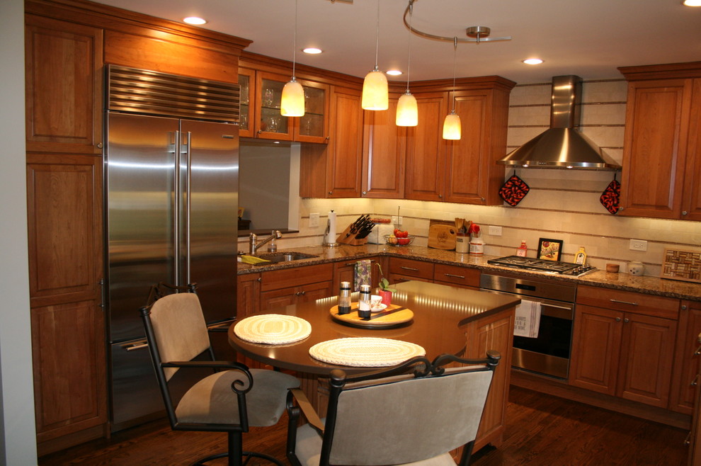 Inspiration for a mid-sized transitional l-shaped dark wood floor enclosed kitchen remodel in Chicago with an undermount sink, raised-panel cabinets, medium tone wood cabinets, quartz countertops, beige backsplash, stone tile backsplash, stainless steel appliances and an island