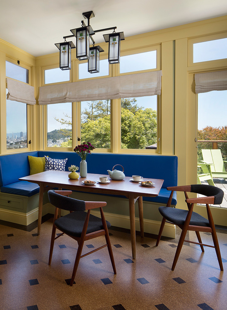This is an example of a small midcentury dining room in San Francisco with yellow walls, vinyl floors and brown floor.
