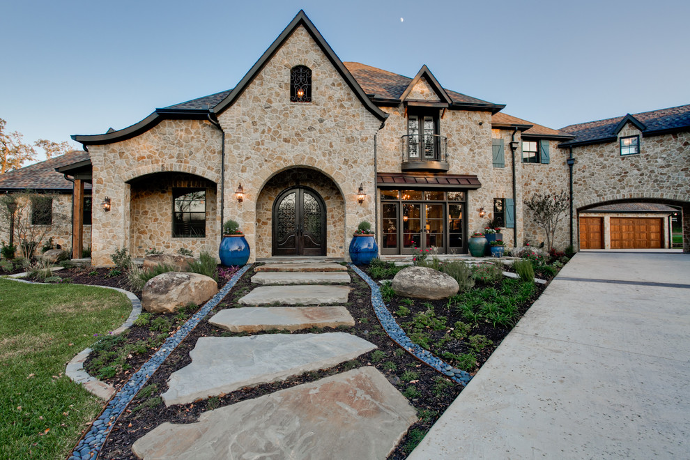 Inspiration for a large mediterranean two-storey beige exterior in Dallas with stone veneer.