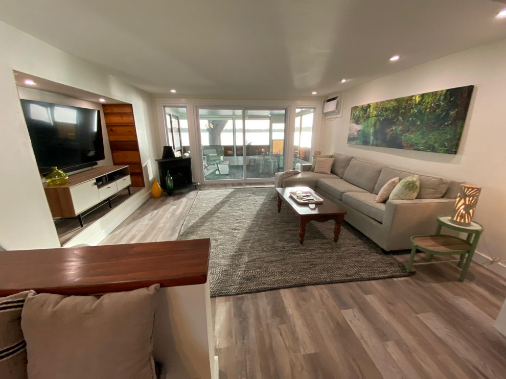 Immagine di un piccolo soggiorno shabby-chic style con pareti bianche, pavimento in vinile, TV a parete e pavimento grigio