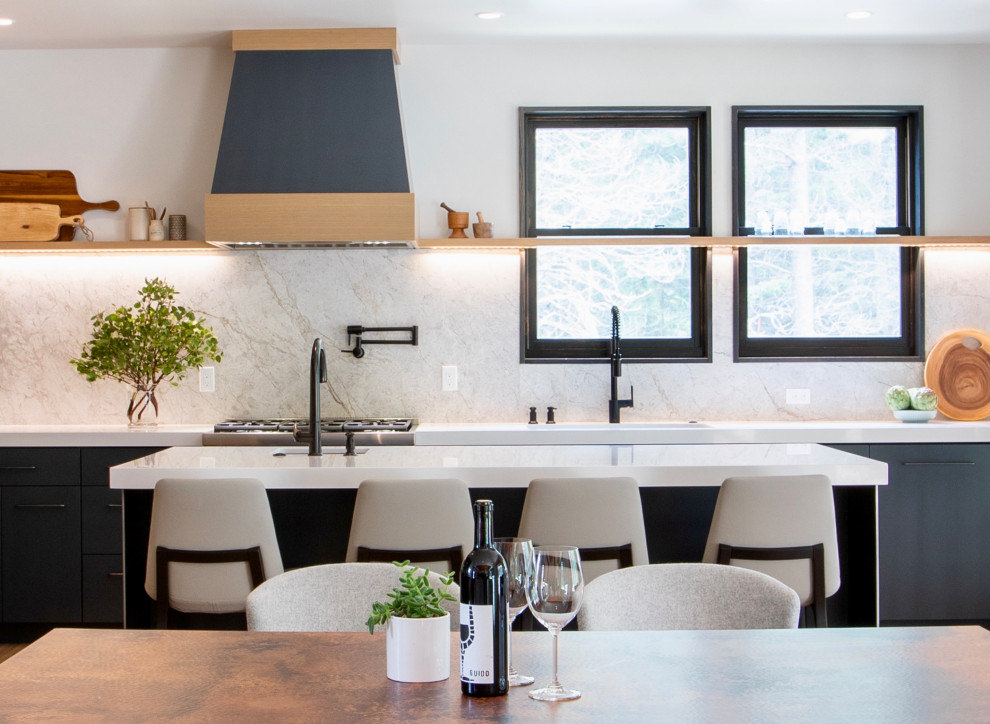 Inredning av ett modernt mellanstort vit vitt kök, med en undermonterad diskho, släta luckor, blå skåp, bänkskiva i koppar, grått stänkskydd, stänkskydd i kalk, integrerade vitvaror, ljust trägolv, en köksö och brunt golv