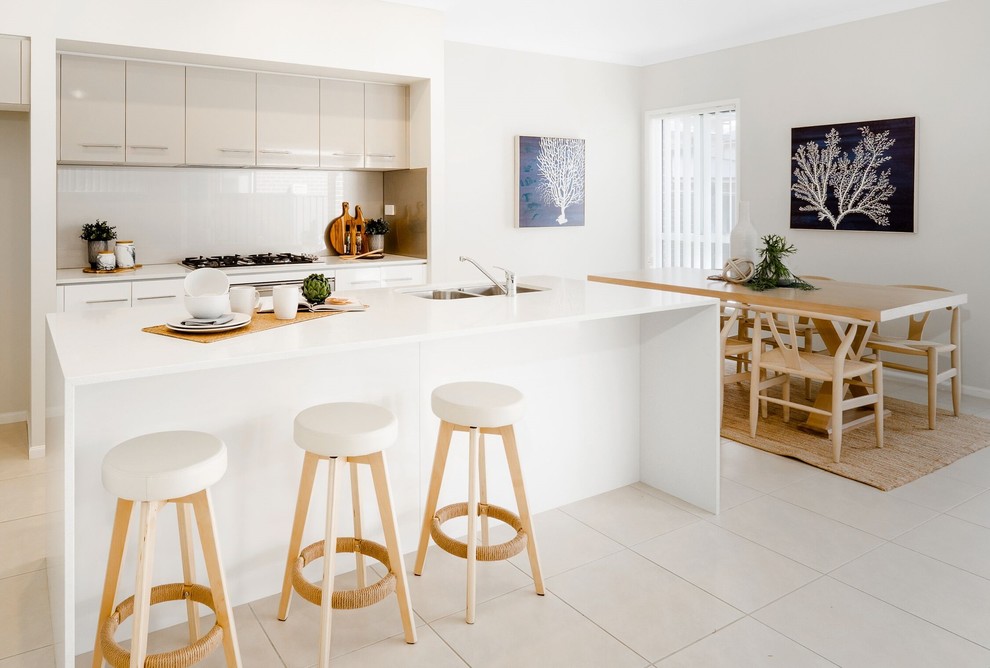 Inspiration for a mid-sized contemporary galley open plan kitchen in Sydney with an undermount sink, flat-panel cabinets, white cabinets, quartz benchtops, brown splashback, glass sheet splashback, stainless steel appliances, cement tiles, with island, beige floor and white benchtop.