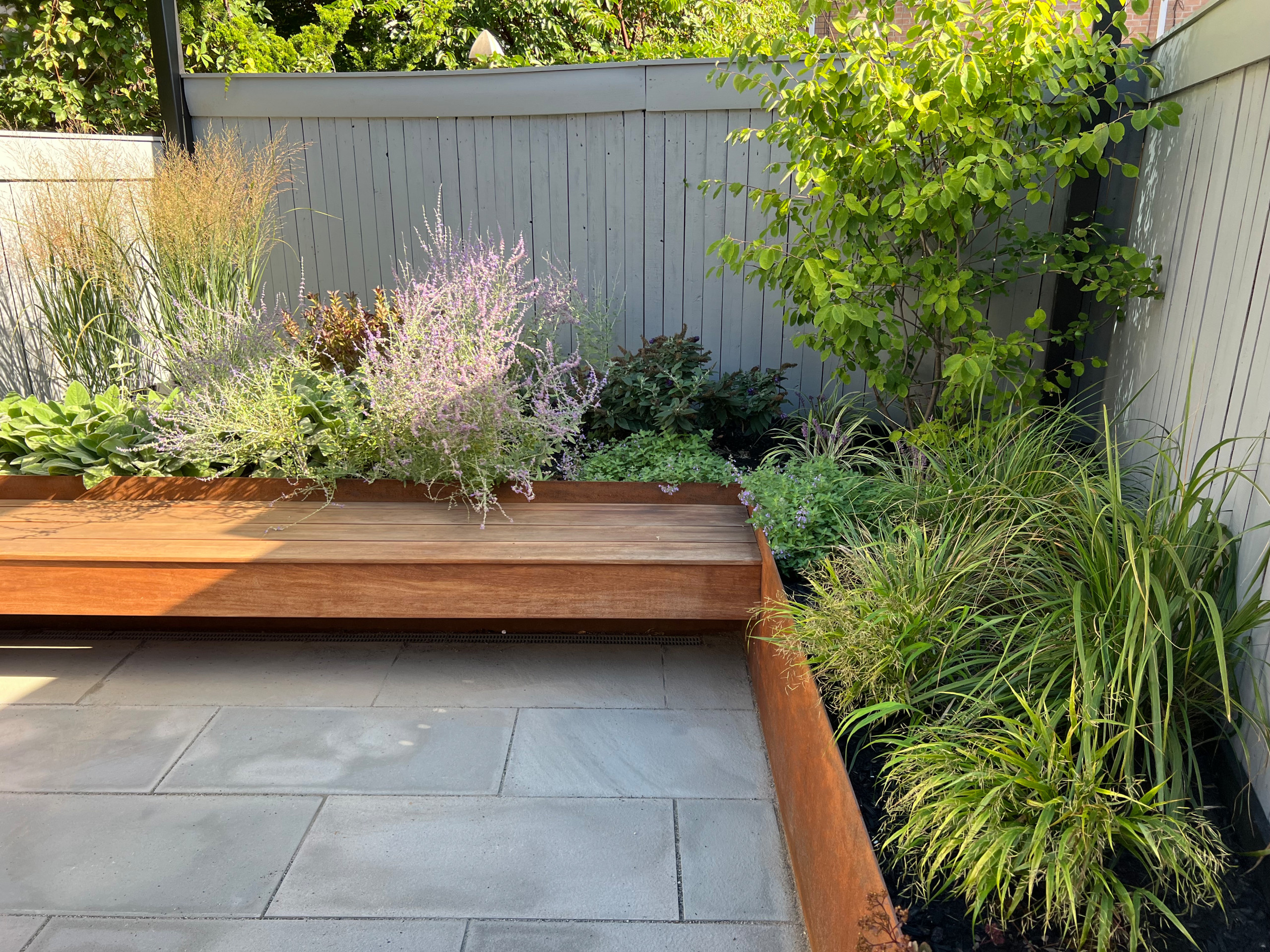 Paved patio with metal grating garden