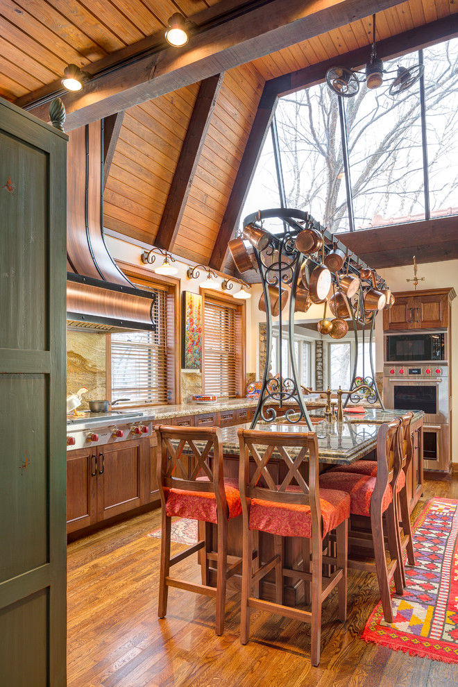 Inspiration for a large timeless l-shaped medium tone wood floor open concept kitchen remodel in Kansas City with a double-bowl sink, beaded inset cabinets, medium tone wood cabinets, granite countertops, brown backsplash, stone slab backsplash, stainless steel appliances and an island