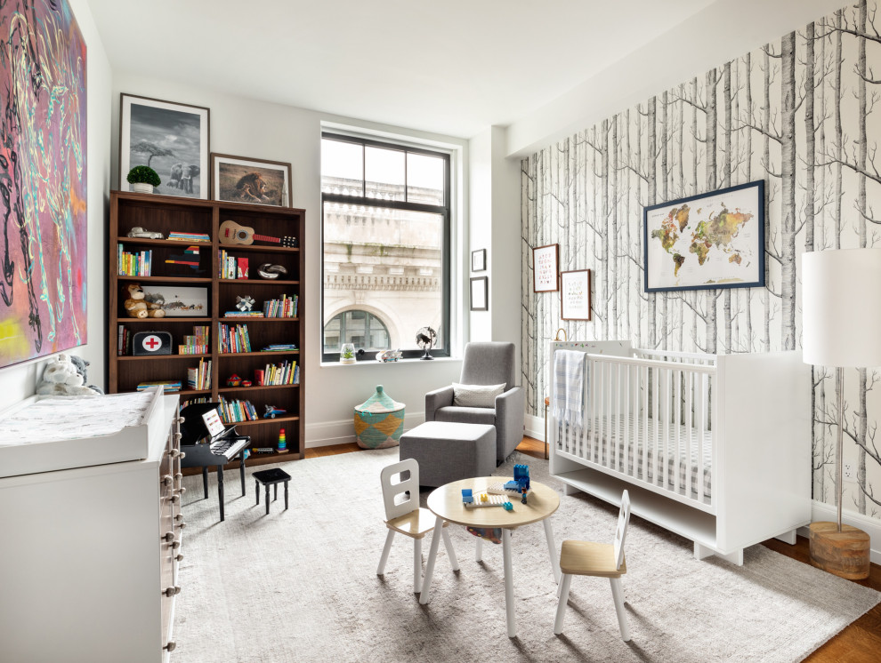 This is an example of a mid-sized eclectic nursery for boys in New York with multi-coloured walls, medium hardwood floors, brown floor and wallpaper.