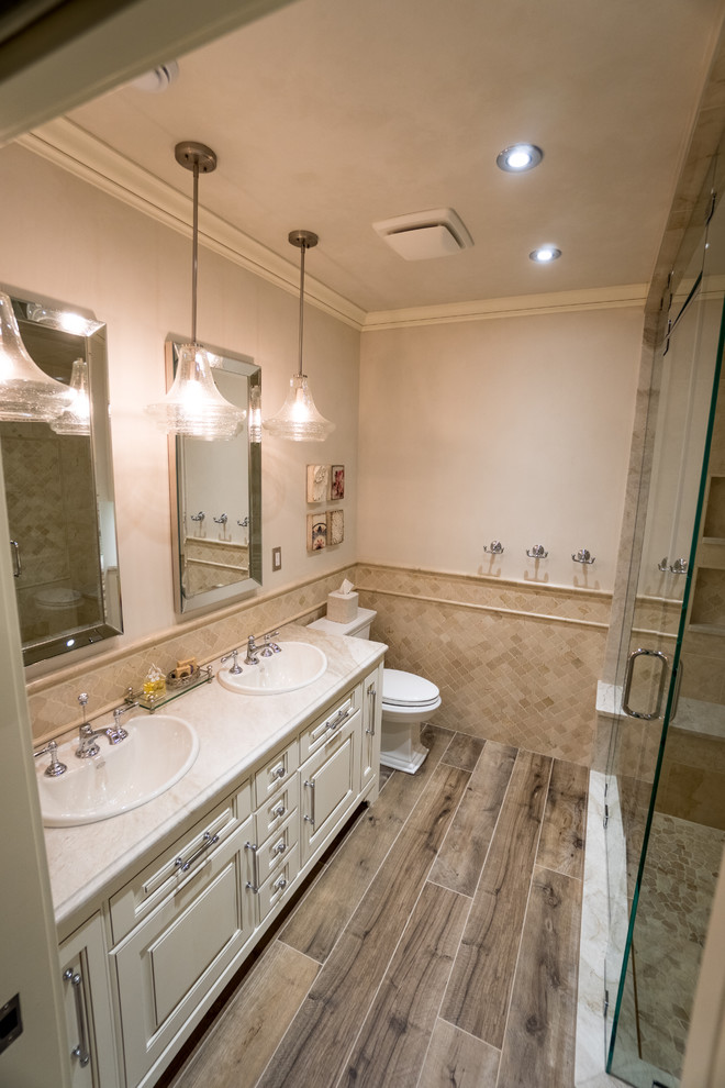 Example of a large mountain style walk-out medium tone wood floor and brown floor bathroom design in Calgary with gray walls, a hanging fireplace and a stone fireplace