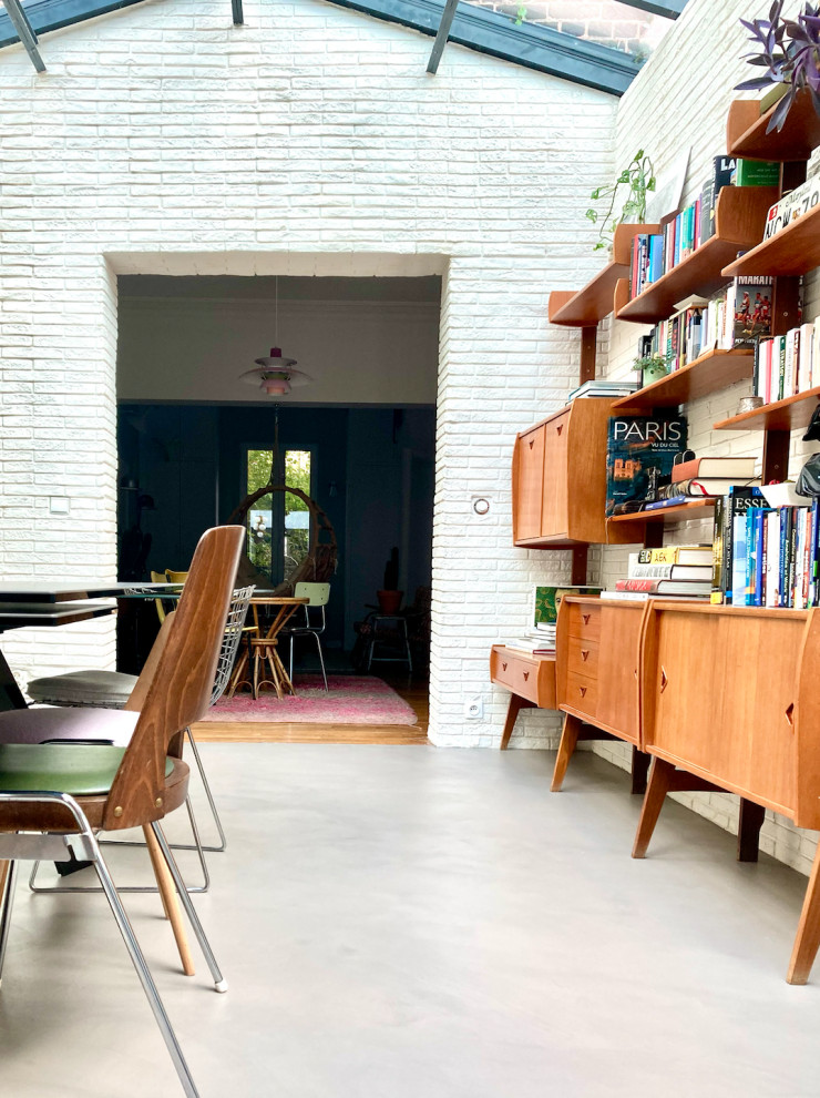 Идея дизайна: большая гостиная-столовая в стиле фьюжн с белыми стенами, бетонным полом, серым полом и кирпичными стенами