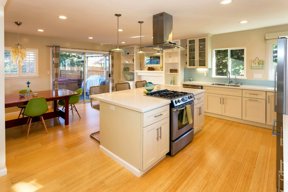 Design ideas for a mid-sized beach style l-shaped open plan kitchen in San Francisco with an undermount sink, shaker cabinets, beige cabinets, terrazzo benchtops, blue splashback, ceramic splashback, stainless steel appliances, light hardwood floors and with island.