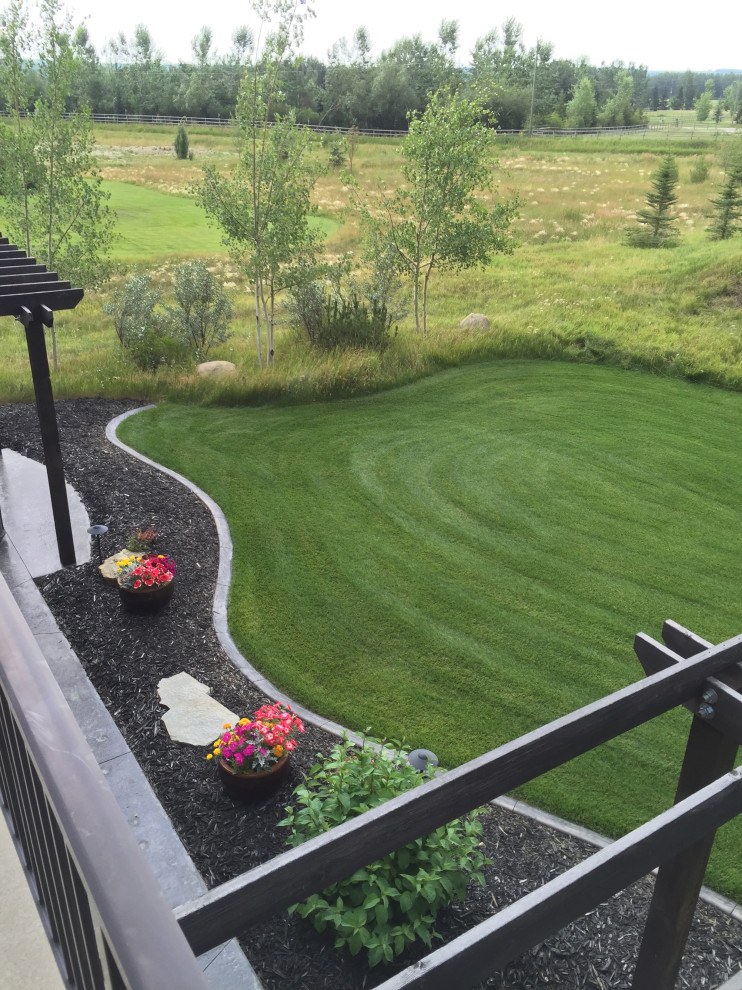 This is an example of a large backyard garden in Calgary with with privacy feature.