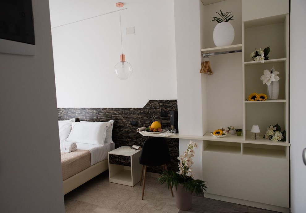 This is an example of a small modern guest bedroom in Catania-Palermo with white walls, porcelain floors, no fireplace and beige floor.