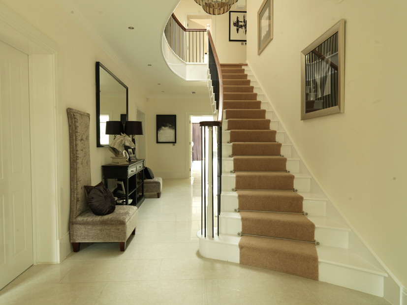 Design ideas for a large traditional painted wood curved staircase in Cambridgeshire with painted wood risers.