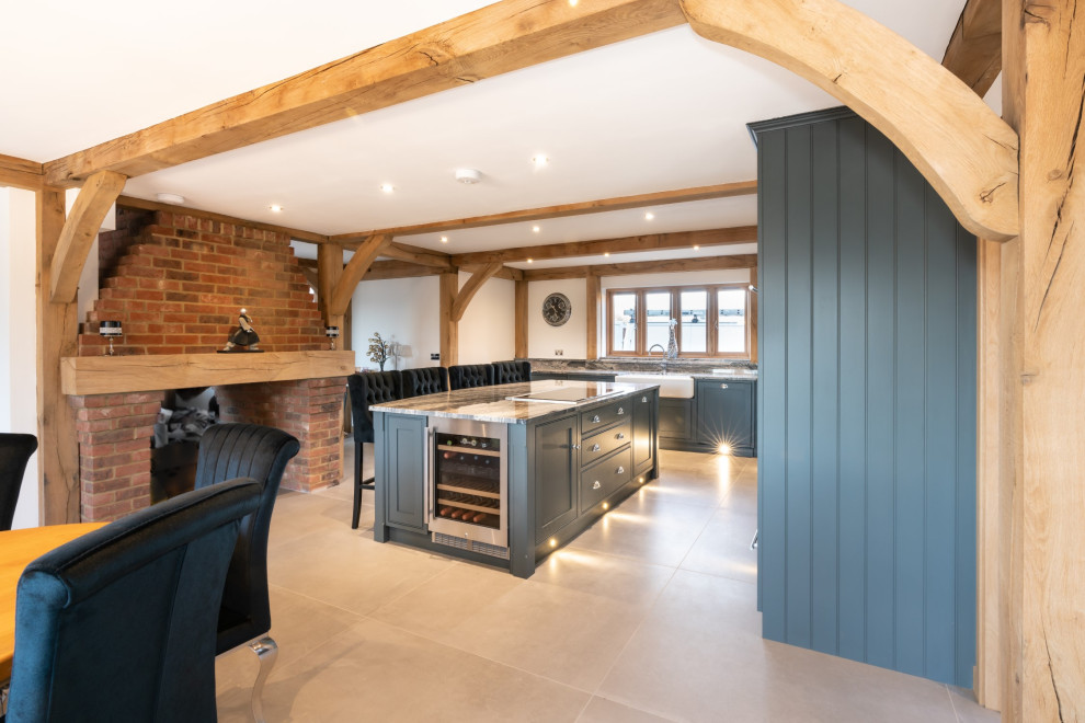 Inspiration for an expansive transitional l-shaped open plan kitchen in Essex with a double-bowl sink, recessed-panel cabinets, grey cabinets, granite benchtops, panelled appliances, travertine floors, with island, beige floor and grey benchtop.