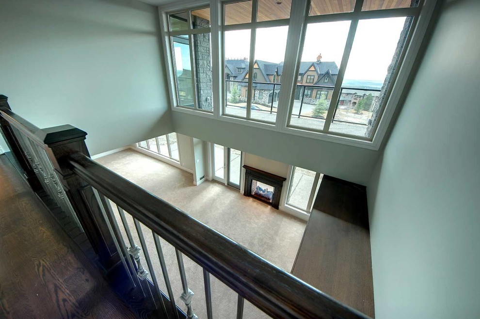 Inspiration for a large transitional walk-out carpeted and beige floor home design remodel in Calgary with gray walls, a two-sided fireplace and a tile fireplace