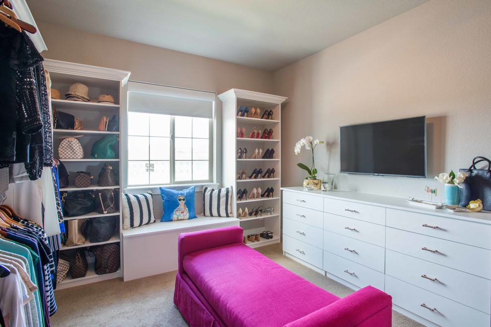 This is an example of a large modern women's dressing room in Denver with carpet and white cabinets.