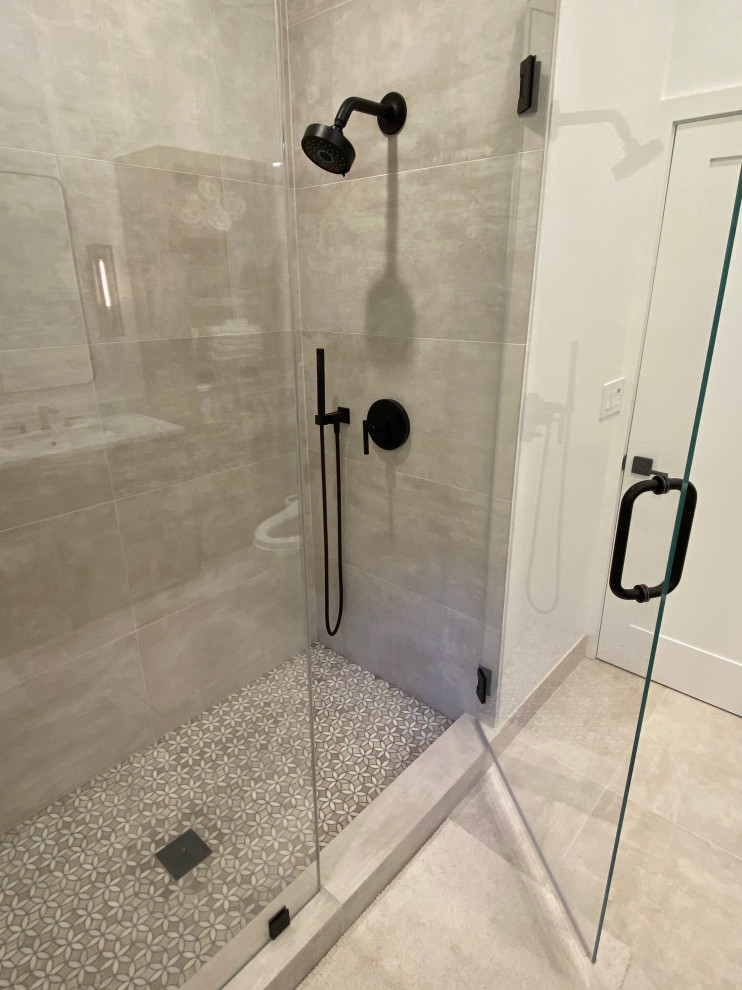 Photo of a medium sized modern ensuite bathroom in San Francisco with medium wood cabinets, an alcove shower, a one-piece toilet, beige tiles, porcelain tiles, beige walls, porcelain flooring, a submerged sink, marble worktops, beige floors, a hinged door, white worktops, a wall niche, double sinks and a freestanding vanity unit.