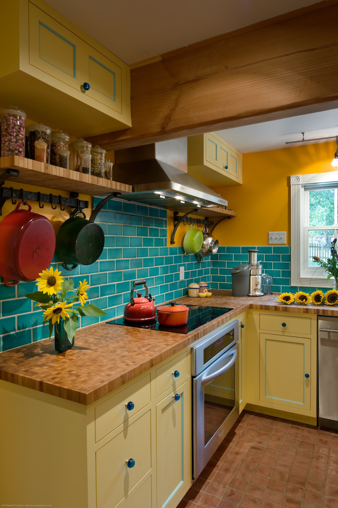 Country u-shaped separate kitchen in Denver with subway tile splashback, wood benchtops, yellow cabinets, recessed-panel cabinets, stainless steel appliances and a farmhouse sink.