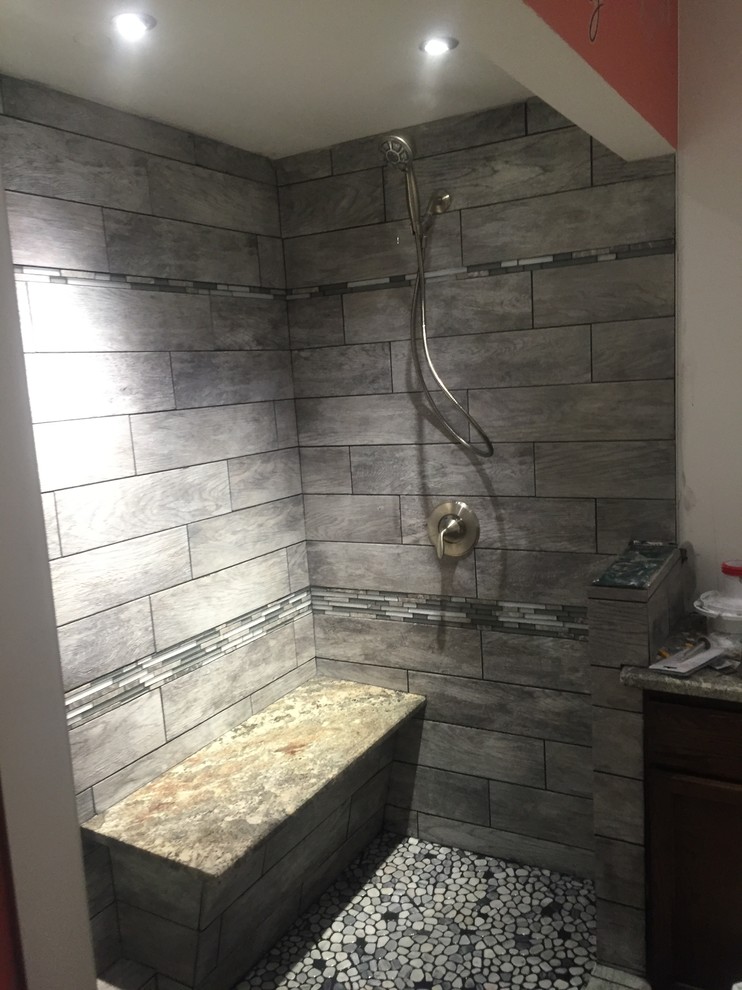 Mid-sized contemporary 3/4 bathroom in Cleveland with an alcove shower, gray tile, porcelain tile and orange walls.