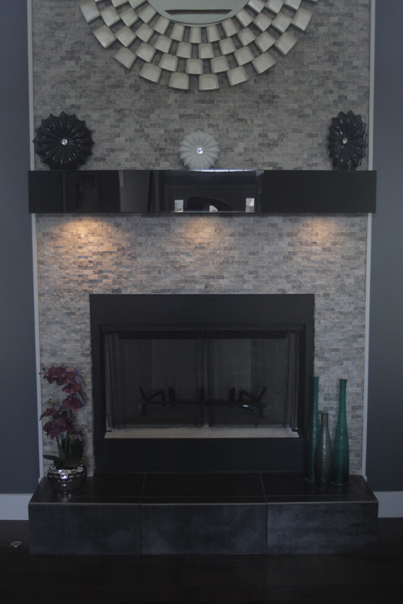 This is an example of a modern living room in Chicago with grey walls, dark hardwood floors, a standard fireplace and a stone fireplace surround.