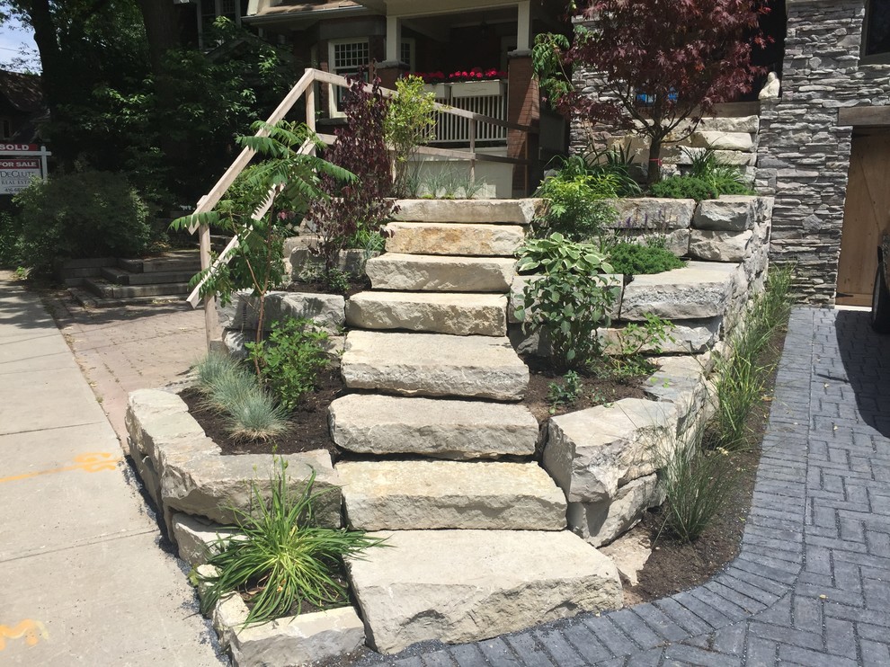 This is an example of a mid-sized rustic partial sun front yard stone driveway in Orange County for summer.
