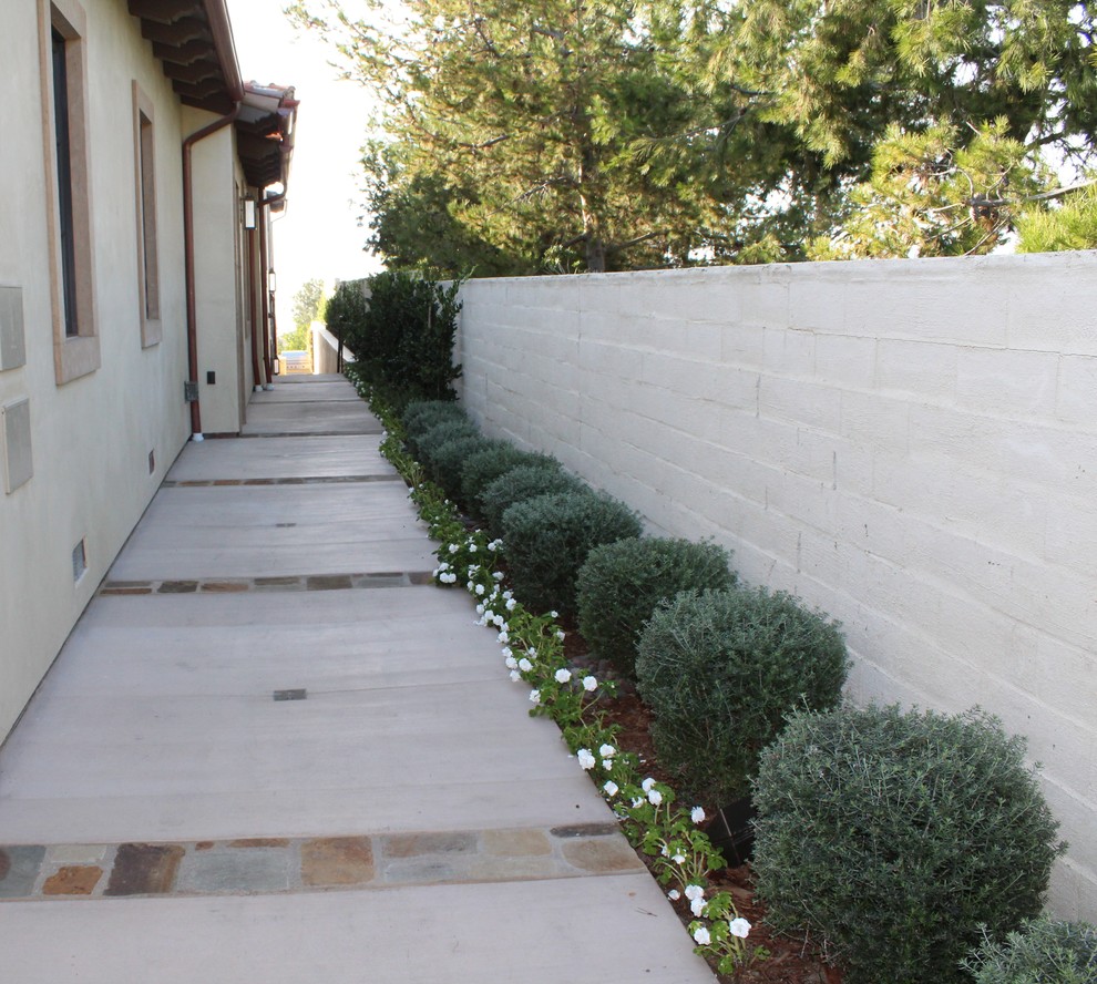 Design ideas for a mediterranean front yard driveway in Orange County with a garden path and natural stone pavers.