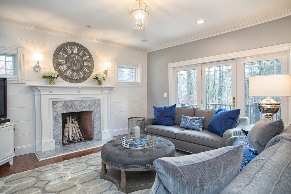 Inspiration for a mid-sized transitional open concept living room in Boston with grey walls, a stone fireplace surround, a freestanding tv, medium hardwood floors, a standard fireplace and brown floor.