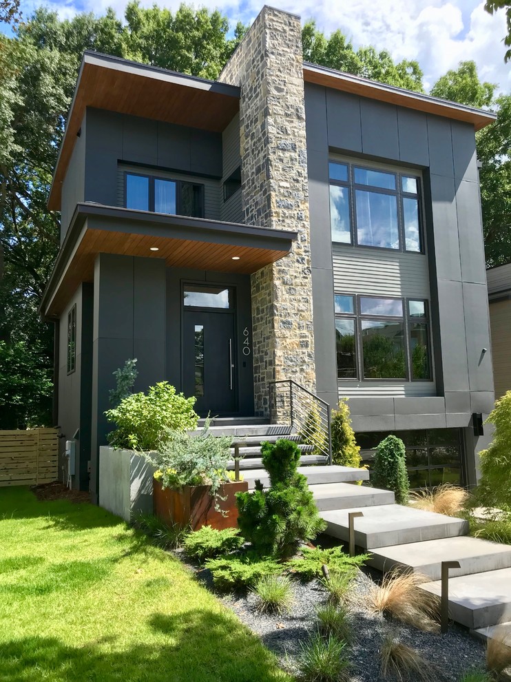 This is an example of a mid-sized modern three-storey grey exterior in Atlanta with concrete fiberboard siding and a flat roof.