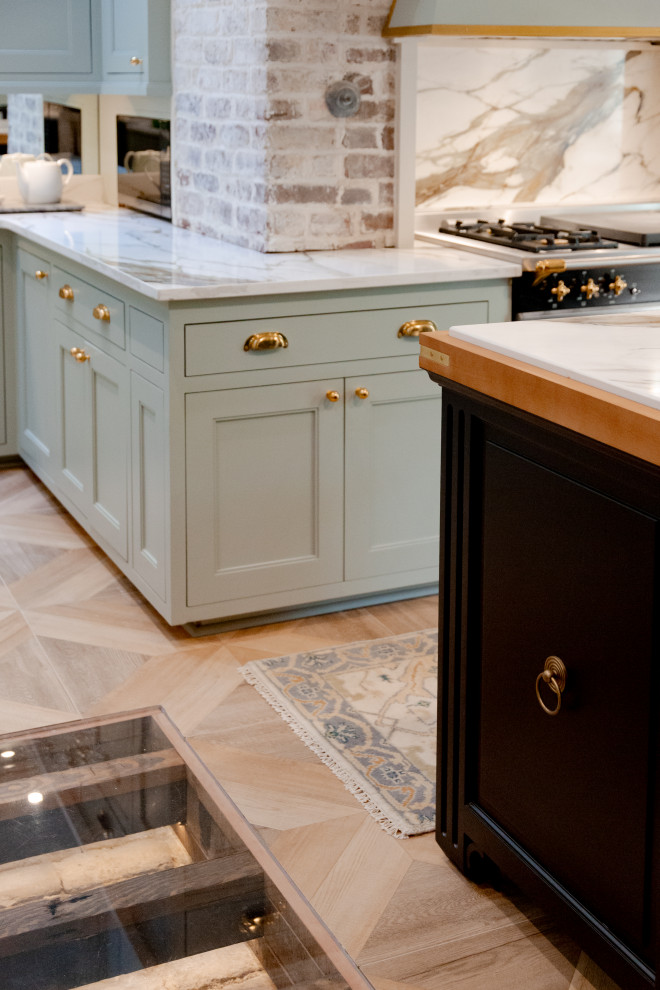 Kitchen - large transitional u-shaped porcelain tile and brown floor kitchen idea in Charleston with an undermount sink, shaker cabinets, green cabinets, marble countertops, beige backsplash, an island and beige countertops