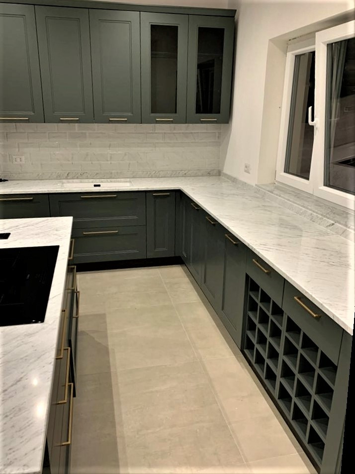 Exempel på ett avskilt, stort modernt vit vitt l-kök, med en undermonterad diskho, luckor med upphöjd panel, gröna skåp, marmorbänkskiva, vitt stänkskydd, stänkskydd i marmor, svarta vitvaror, klinkergolv i porslin, en köksö och beiget golv