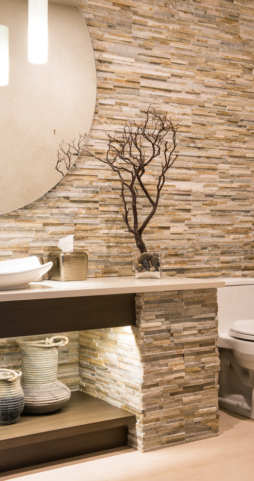 Example of a transitional beige tile and stone tile bathroom design with a vessel sink and quartz countertops
