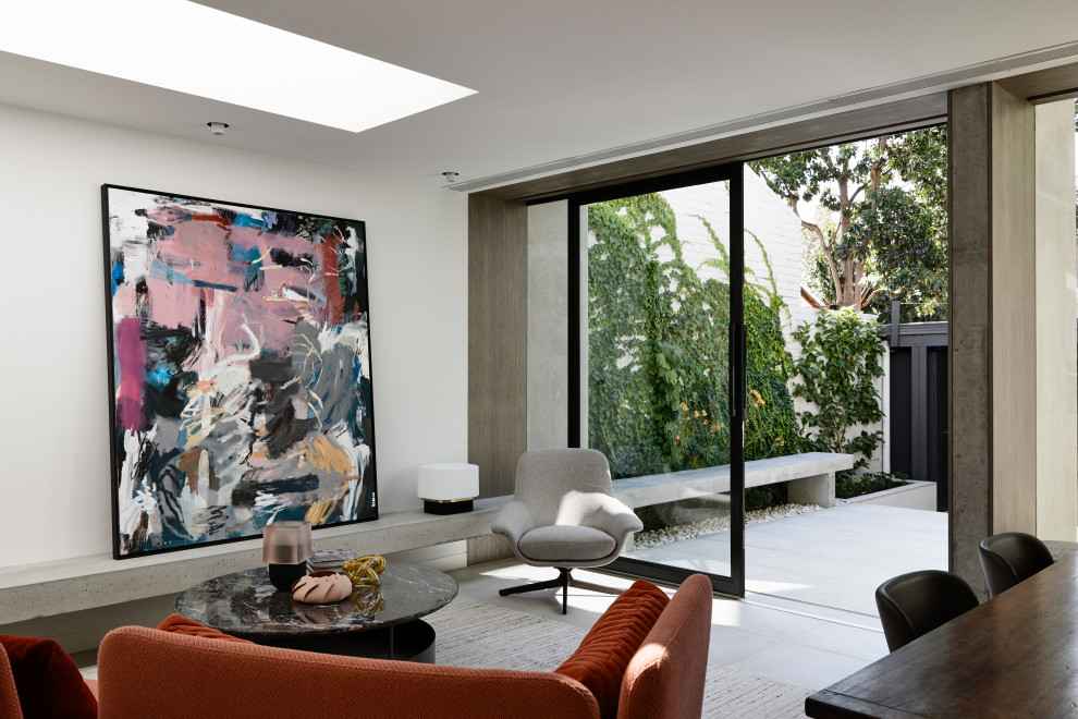 Contemporary open concept living room in Melbourne with white walls, porcelain floors, no fireplace, a wall-mounted tv and grey floor.