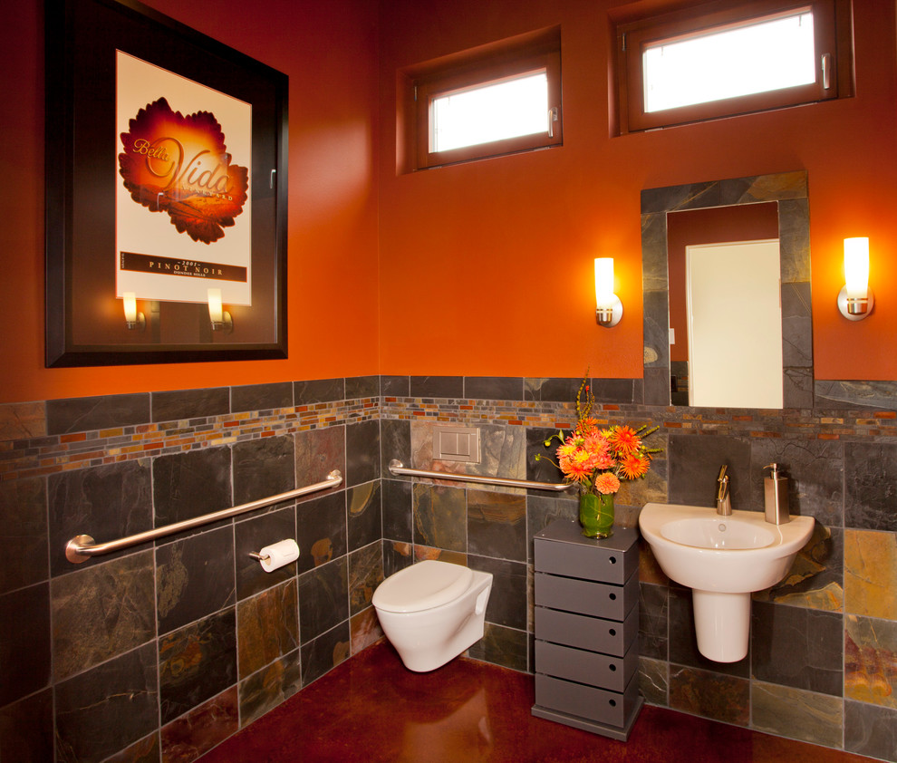 Inspiration for a contemporary bathroom in Portland with a wall-mount sink, a wall-mount toilet, multi-coloured tile, orange walls and slate.