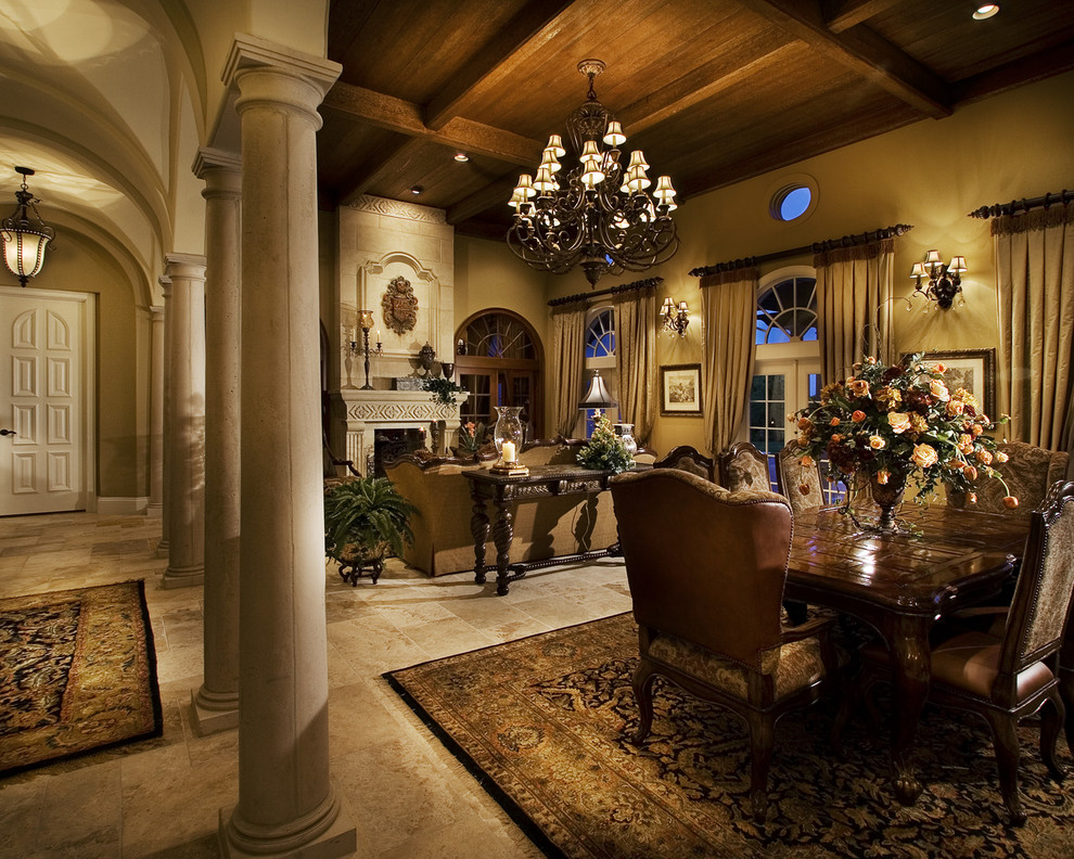 Inspiration for a traditional separate dining room in Orlando with beige walls, limestone floors, a standard fireplace, a plaster fireplace surround and beige floor.