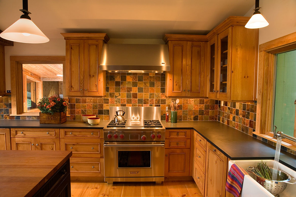 Inspiration for a large rustic u-shaped medium tone wood floor eat-in kitchen remodel in Jacksonville with recessed-panel cabinets, medium tone wood cabinets, multicolored backsplash, slate backsplash, stainless steel appliances, an island and black countertops