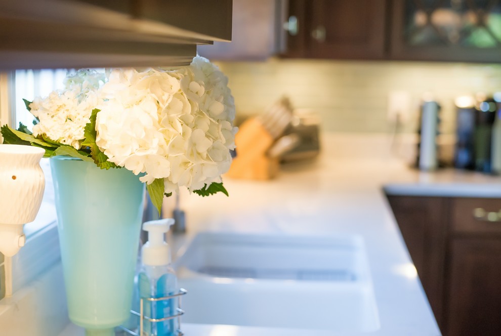 Eat-in kitchen - mid-sized transitional u-shaped eat-in kitchen idea with an undermount sink, dark wood cabinets, blue backsplash, glass tile backsplash, stainless steel appliances and a peninsula