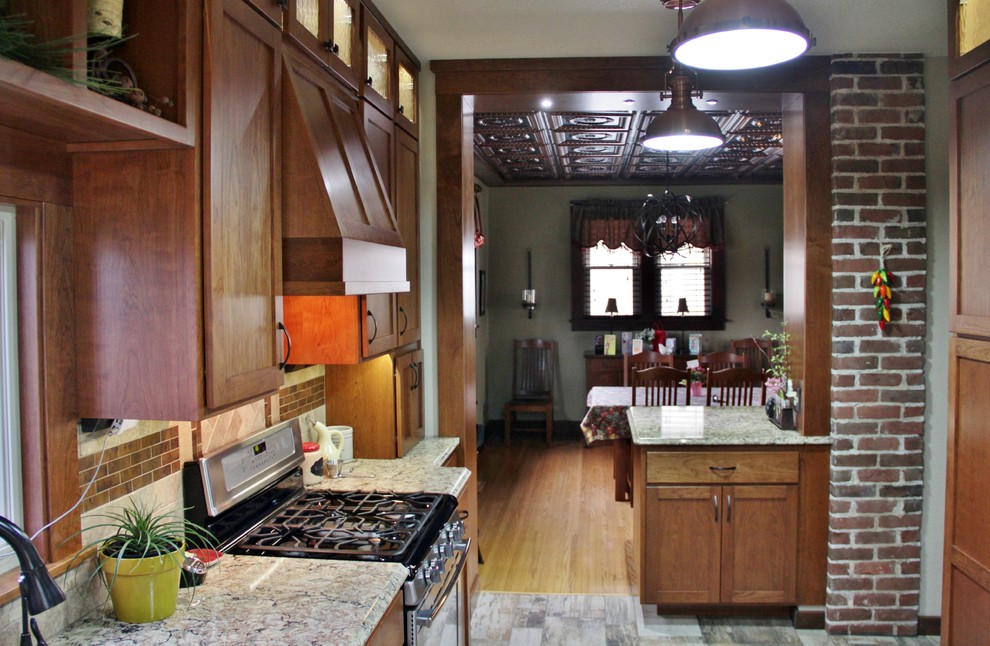 Inspiration for a mid-sized transitional galley ceramic tile enclosed kitchen remodel with an undermount sink, shaker cabinets, medium tone wood cabinets, quartz countertops, beige backsplash, stone tile backsplash, stainless steel appliances and a peninsula