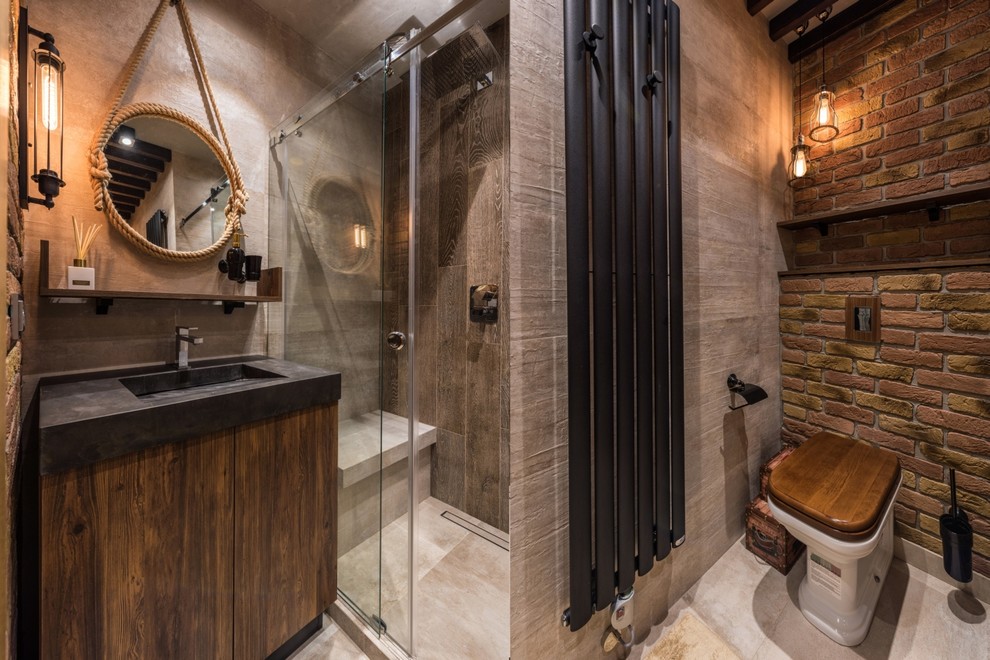 Photo of an industrial 3/4 bathroom in Other with flat-panel cabinets, dark wood cabinets, an alcove shower, a two-piece toilet, brown tile, gray tile, brown walls, an integrated sink, grey floor and a sliding shower screen.