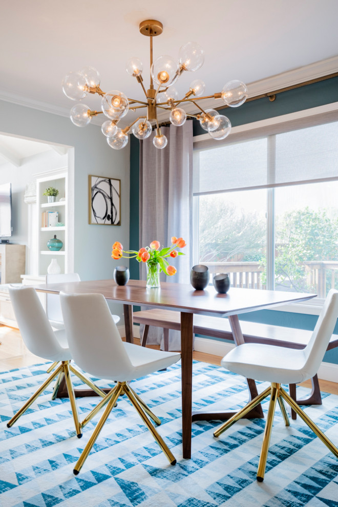 Idee per una sala da pranzo aperta verso la cucina moderna di medie dimensioni con pareti blu, parquet chiaro e pavimento marrone