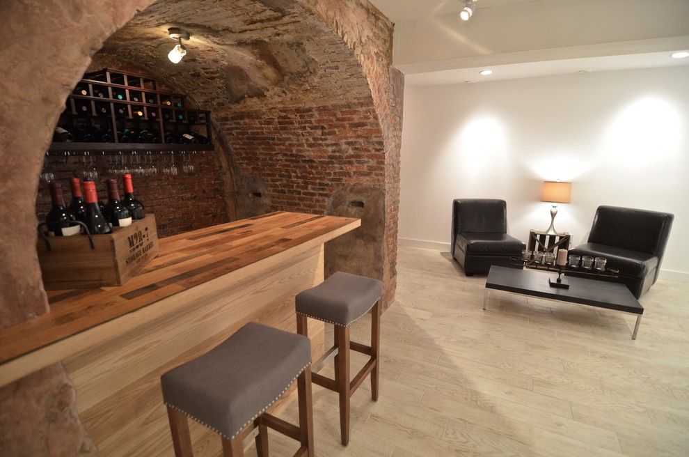 Inspiration for a small country single-wall seated home bar in Boston with wood benchtops, red splashback, brick splashback, light hardwood floors and beige floor.