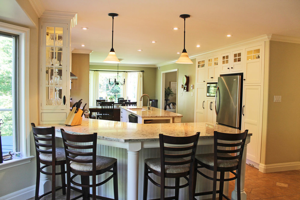 Open concept kitchen - mid-sized transitional u-shaped open concept kitchen idea with an undermount sink, beaded inset cabinets, white cabinets, granite countertops, gray backsplash, ceramic backsplash, stainless steel appliances, an island and beige countertops