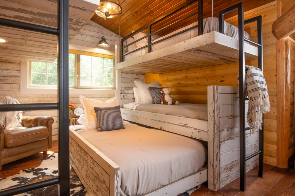 Inspiration for a mid-sized country loft-style bedroom in Other with brown walls, medium hardwood floors, no fireplace, brown floor, vaulted and wood walls.