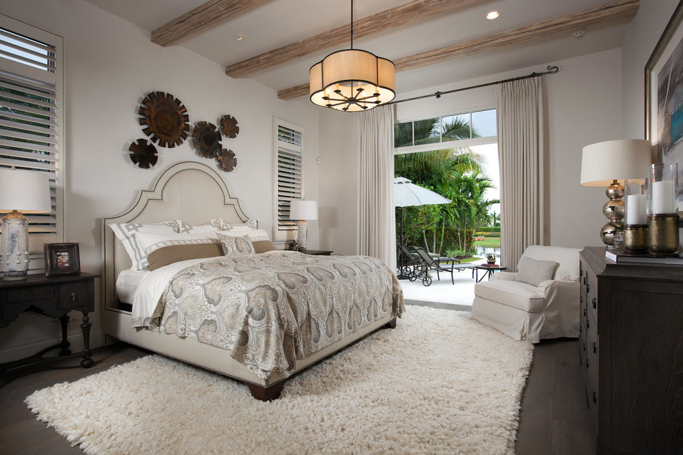 Photo of a mediterranean bedroom in Miami with white walls and dark hardwood floors.