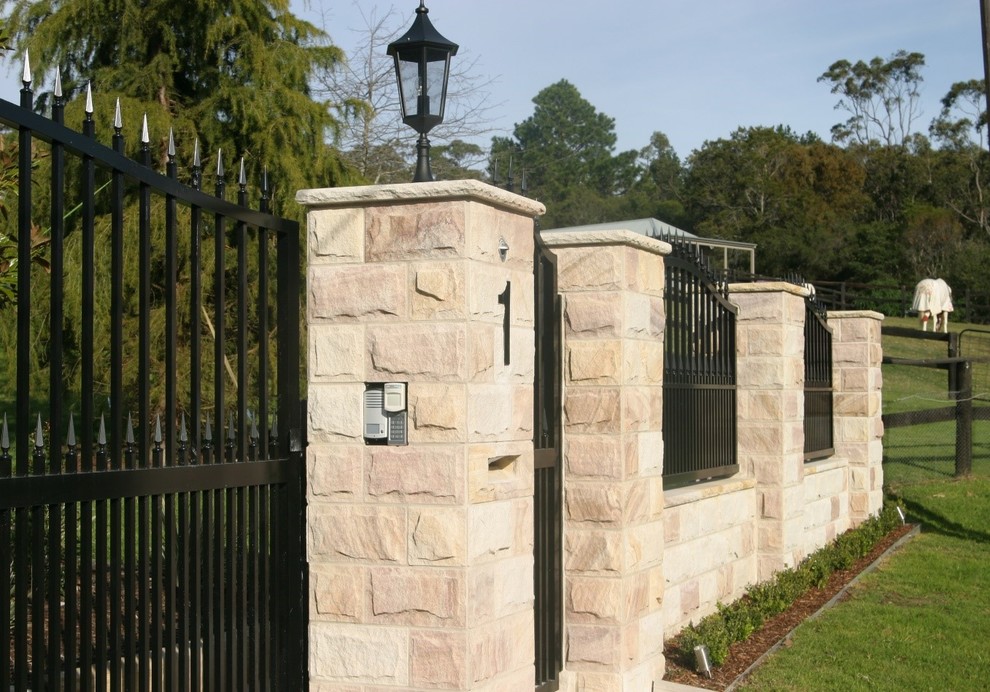 This is an example of a country front yard full sun formal garden in Sydney with a garden path and natural stone pavers.