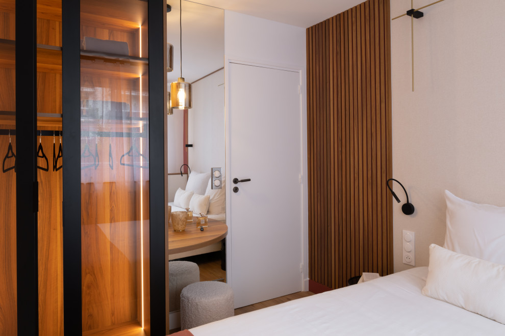 Пример оригинального дизайна: большая гостевая спальня (комната для гостей) в современном стиле с красными стенами, светлым паркетным полом, коричневым полом и панелями на стенах