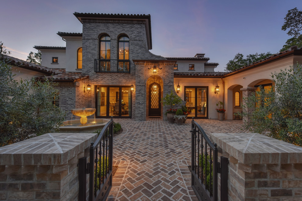 Expansive mediterranean two-storey stucco beige house exterior in Sacramento with a tile roof.