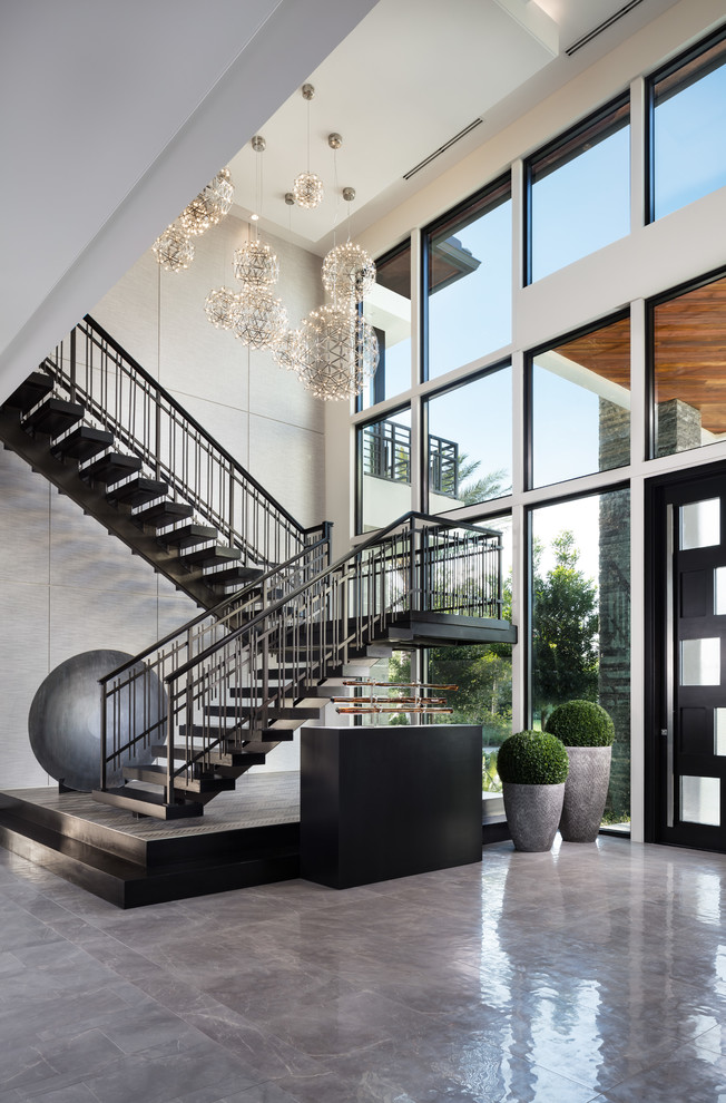 Inspiration for a contemporary foyer in Miami with white walls, a single front door, a black front door and grey floor.