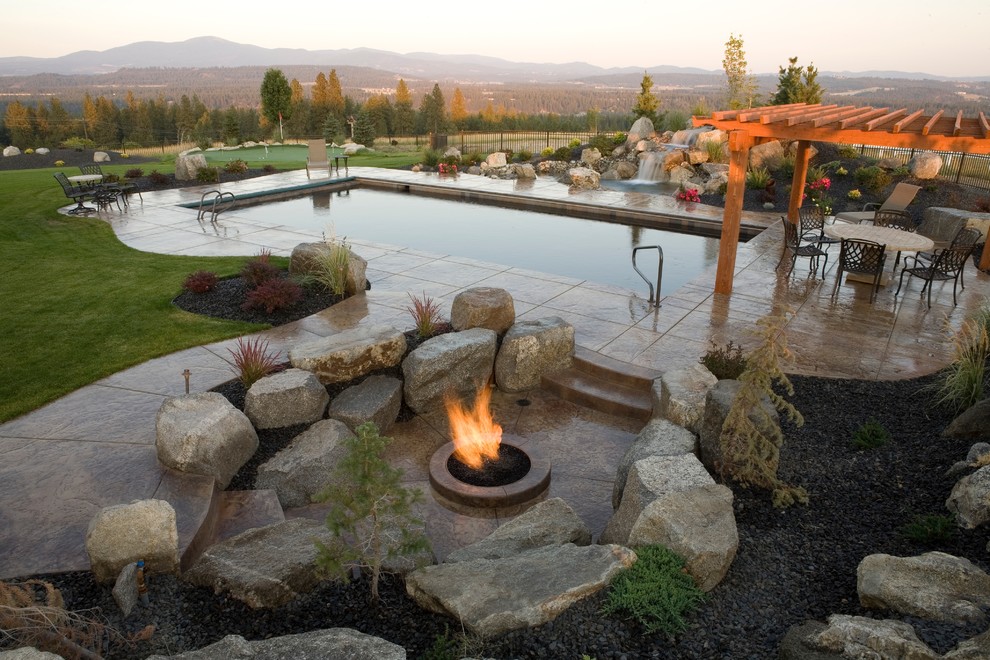Inspiration for a large traditional backyard rectangular pool in Seattle with a water feature and natural stone pavers.