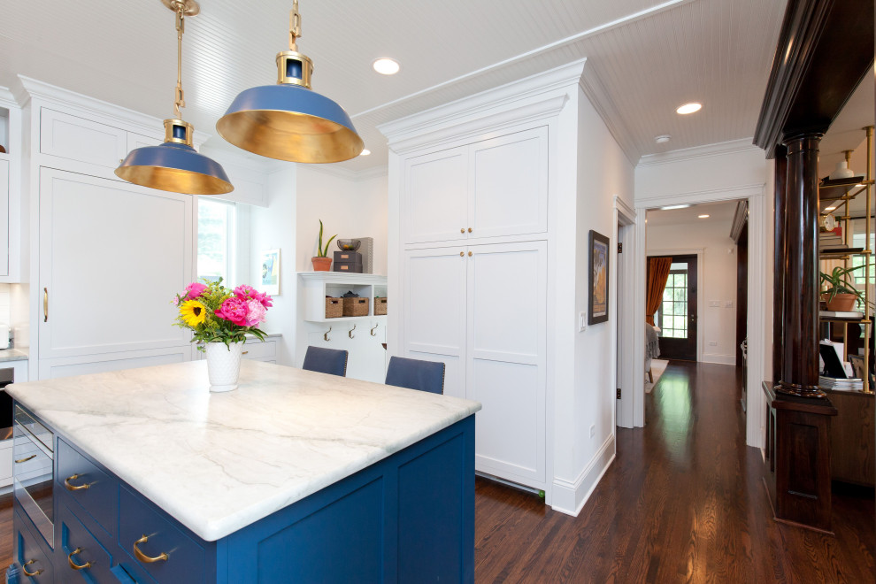 Inspiration for a transitional u-shaped dark wood floor eat-in kitchen remodel in Chicago with a farmhouse sink, shaker cabinets, blue cabinets, quartzite countertops, white backsplash, subway tile backsplash, stainless steel appliances, an island and white countertops
