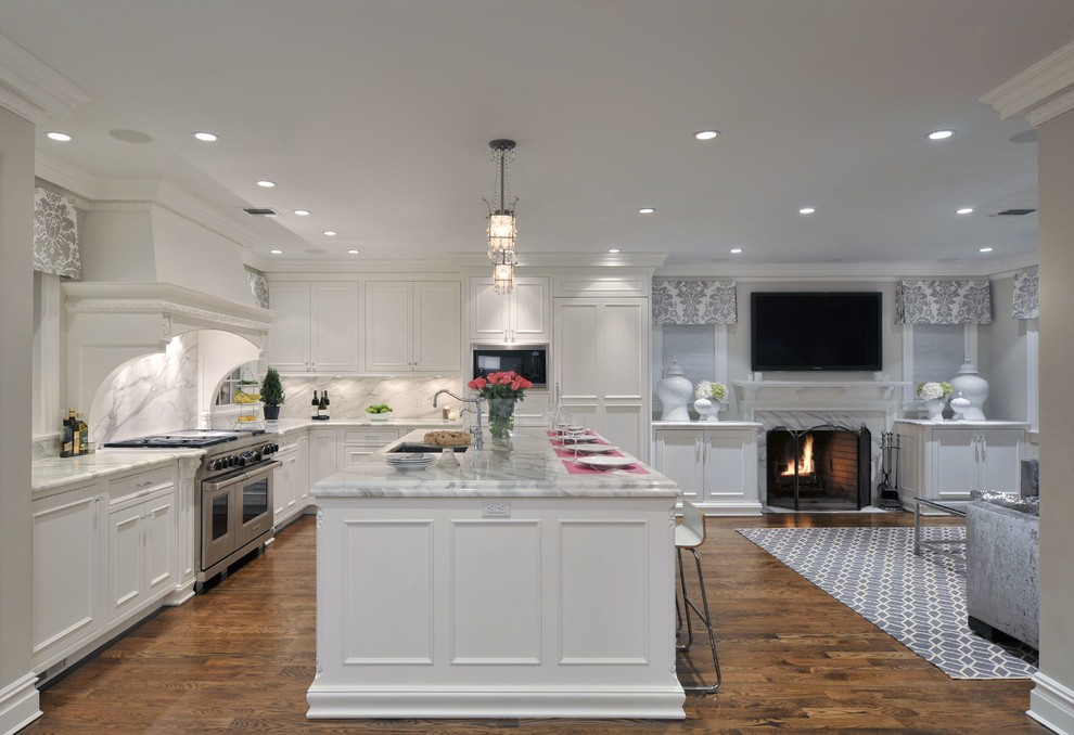 Photo of a large traditional l-shaped open plan kitchen in New York with white cabinets, white splashback, panelled appliances, with island, recessed-panel cabinets, marble benchtops, stone slab splashback, an undermount sink and dark hardwood floors.