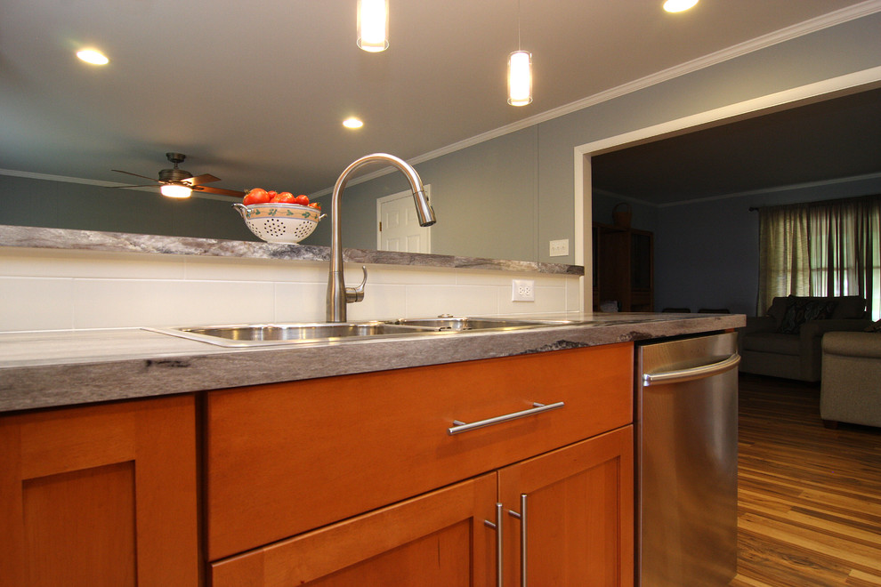 Large transitional u-shaped medium tone wood floor eat-in kitchen photo with a drop-in sink, recessed-panel cabinets, medium tone wood cabinets, laminate countertops, white backsplash, ceramic backsplash, stainless steel appliances and a peninsula